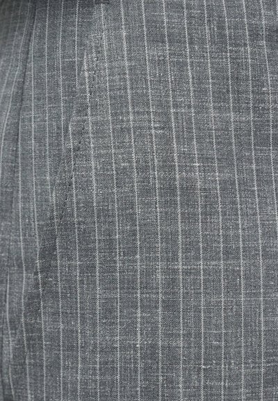 Γκρι ύφασμα με λεπτές λευκές κατακόρυφες ρίγες και ορατή ραφή στην διπλωμένη υφασμάτινη επιφάνεια.