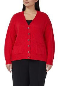 Rode gebreide cardigan met een V-hals, opvallende geribbelde manchetten, twee voorzakken en vijf metalen knopen aan de voorkant.