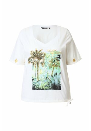 T-shirt blanc à manches courtes avec un col en V, présentant un motif tropical avec des palmiers en sequins et le texte "Tropic Paradise", ainsi qu'un détail noué à l'ourlet.