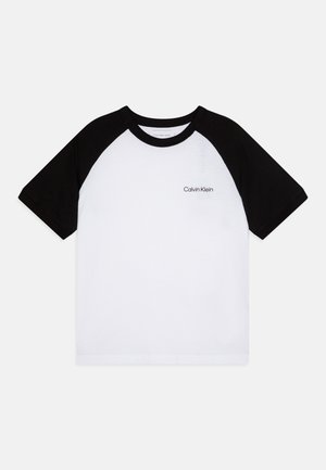 Black raglan short-sleeve T-shirt featuring a white body, black sleeves, and a small "Calvin Klein" logo on the left chest area.