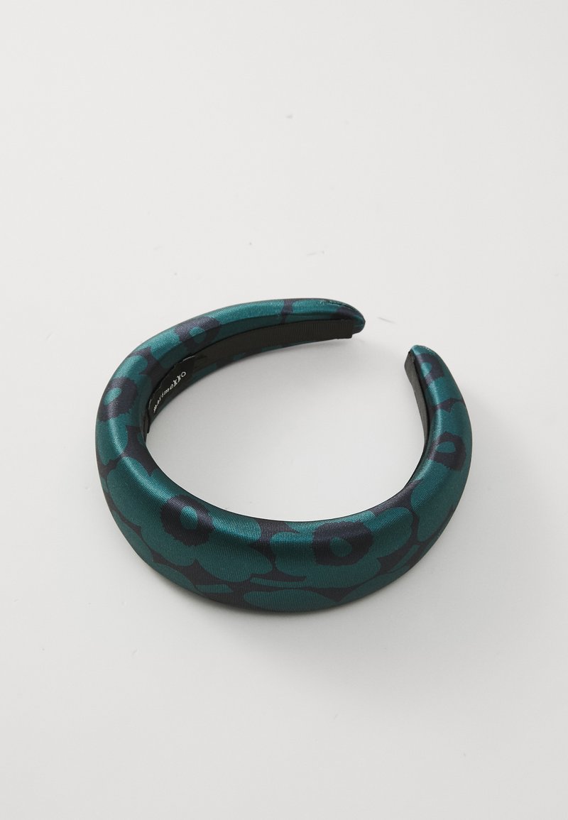 Zaļi un melni ziedu raksta galvas apsējs ar gludu tekstūru, noapaļotām malām un elastīgu dizainu vieglai valkāšanai.