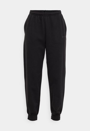 Črne trenirke z elastičnim pasom in rebrastimi manšetami. Narejene iz mehkega materiala, z diskretnim logotipom blagovne znamke na strani.