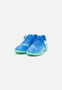 Scarpe sportive sintetiche blu con un motivo testurizzato, dotate di suole e lacci in gomma verde. Logo bianco ben visibile sul lato.