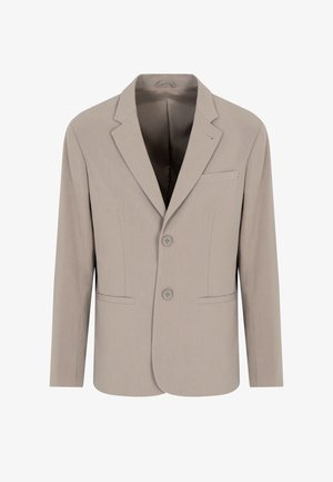 Blazer beige sartoriale con due bottoni, rever a toppa, tasche frontali e una texture liscia. Interno foderato con un colore uniforme.