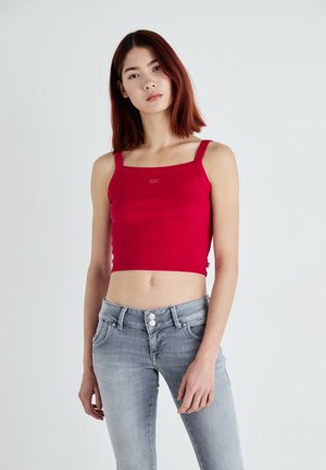 Top corto rosso a coste con scollatura quadrata e spalline spesse. Abbinato a jeans in denim grigio chiaro con vita alta e chiusura a due bottoni.