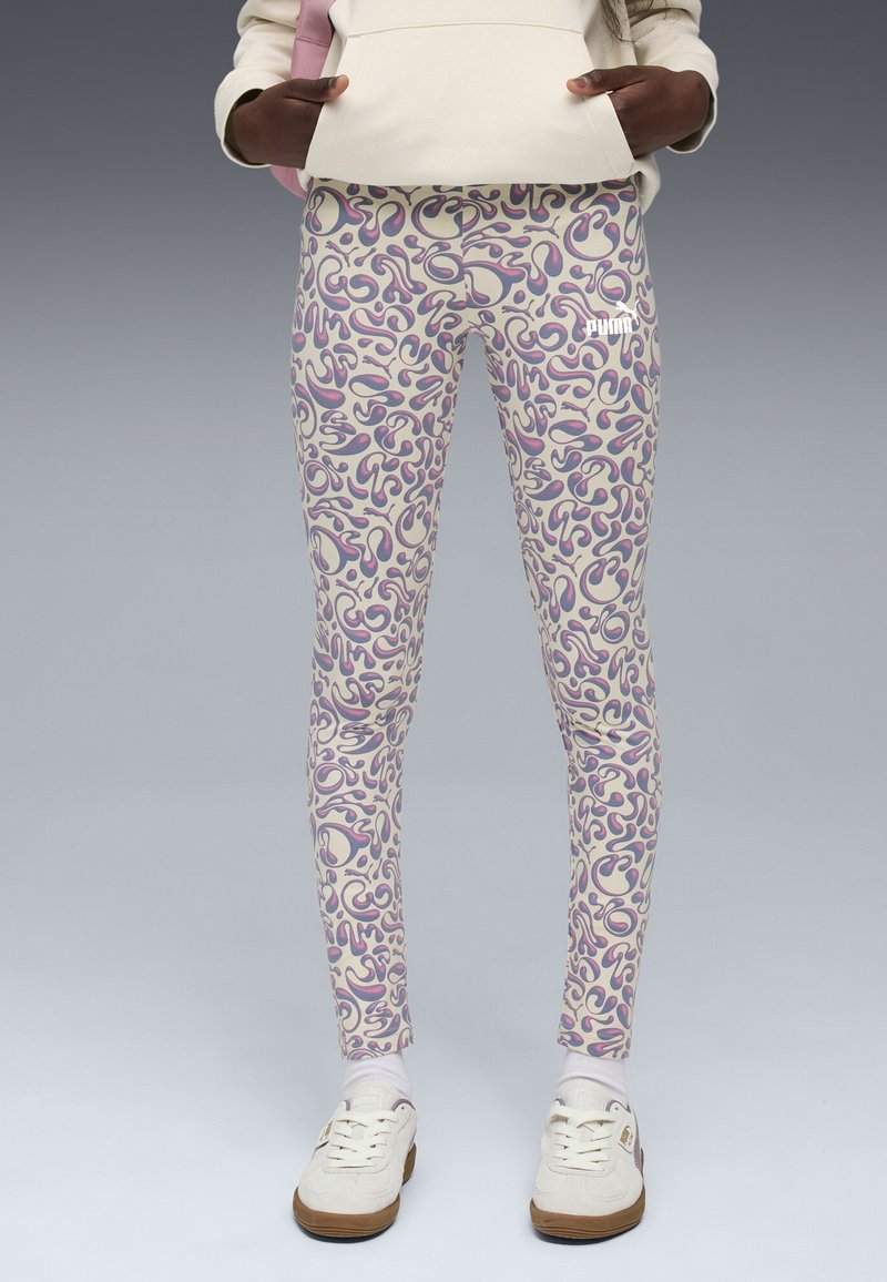 Leggings de couleur crème avec un motif abstrait fantaisiste en violet et rose. Ils offrent un ajustement près du corps et un subtil logo sur la cuisse.