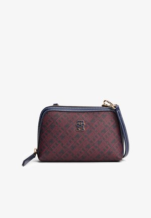Porte-monnaie rectangulaire en cuir rouge foncé et bleu marine avec un motif géométrique, une fermeture éclair supérieure et un petit logo en métal à l'avant.