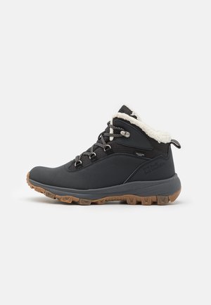 Bottes de randonnée noires avec une tige texturée, un col rembourré et une semelle en caoutchouc à crampons. Comprend des œillets en métal et une doublure en fourrure crème contrastante.