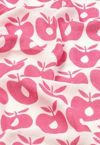 Katoenen stof met een herhalend patroon van roze appels en groene bladeren op een witte achtergrond; zachte textuur met een licht doorschijnende uitstraling.