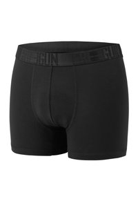 Black boxer shorts made of smooth fabric, featuring a wide elastic waistband with prominent logo and a snug fit design.