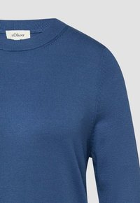 Blauwe gebreide trui met lange mouwen, geribde ronde hals en s.Oliver merklabel aan de binnenkant van de kraag.