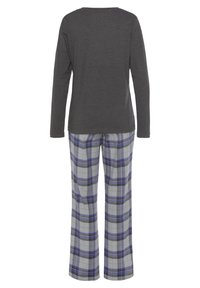 Graues Langarmshirt, kombiniert mit blau-grauen karierter Hose. Lockerer Schnitt, weicher Stoff und karierte Muster auf der Hose.