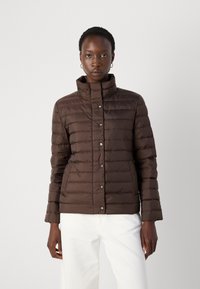 Doudoune matelassée marron avec un col haut, ornée de boutons-pression en argent et d'une silhouette ajustée. Texture lisse, design minimal.