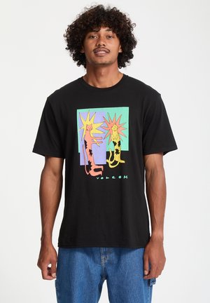 Black cotton t-shirt featuring a colorful graphic of two leopards against a pastel background, with "VOLCOM" text at the bottom.