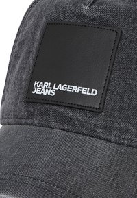 Cappello in denim nero con una patch in pelle quadrata con la scritta "KARL LAGERFELD JEANS" stampata in bianco. Tessuto strutturato con design rigido.
