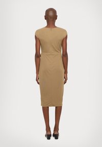 Khaki přiléhavé šaty s krátkými rukávy, silueta ke kolenům a zipem na zadní straně. Měkká textura s bezšvým designem.