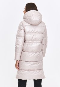 Padded coat w kolorze jasnoróżowym z błyszczącym wykończeniem, z dużym kapturem, długimi rękawami i pionowymi wzorami szwów. Długość do połowy uda.