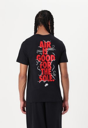 Black Nike T-shirt featuring bold red text on the back: "AIR IS GOOD FOR THE SOLE." Short sleeves and a crew neckline.