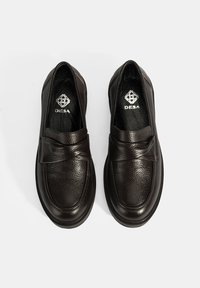 Donkerbruine leren loafers met een gestructureerde afwerking, platte zool en een gestikte voorband. Logo geperst aan de binnenkant van de schoen.