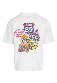Balta trumpa rankovė t-shirt su retro stiliaus grafikų pleistrais, įskaitant raides ir dizainus raudonos, mėlynos, geltonos ir juodos spalvų.