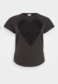 T-paita tummanharmaana, lyhythihaisena, jossa on keskellä teksturoitu mustasta pitsistä tehty sydänkuvio. Pyöreä pääntie, rento leikkaus.
