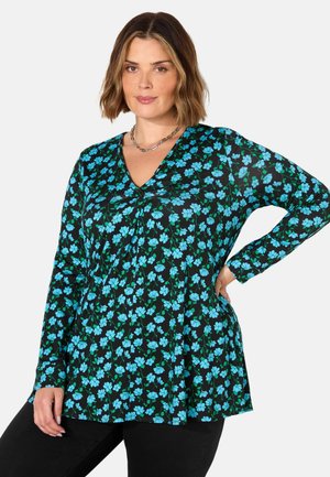 Blusa nera a maniche lunghe con scollo a V, caratterizzata da un motivo floreale di fiori blu e foglie verdi su uno sfondo scuro. Tessuto morbido con pieghe.