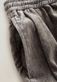 Grijze, gestructureerde stoffen shorts met een elastische tailleband en geplooid ontwerp. Voorzien van zijzakken voor extra gemak.