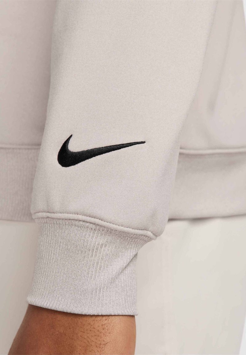 Hellgraue Sweatshirtärmel aus weichem Stoff, mit einem schwarzen Nike-Swoosh-Logo und gerippten Bündchen mit strukturiertem Finish.