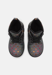 Botines negros brillantes con patrones de corazones multicolores, cordones en la parte delantera, tela texturizada y suela resistente.