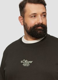Dunkelgrüner Pullover mit Rundhalsausschnitt, auf der Brust mit weiß gesticktem Text "s.Oliver Elevated Essentials Since 1969".