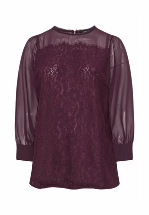 Burgundowa bluzka z przezroczystymi długimi rękawami i koronkowym wykończeniem. Okrągły dekolt i ściągacze przy mankietach. Zapięcie z tyłu z małym otworem w kształcie klucza.