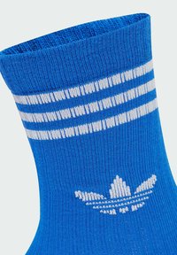 Calzino in cotone blu con design a righe, caratterizzato da righe bianche nella parte superiore e un logo bianco sul lato.