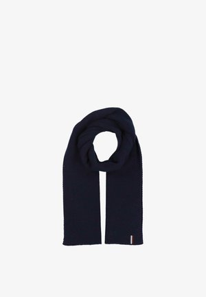 Écharpe en tricot côtelé bleu marine foncé pliée en boucle avec une petite étiquette en tissu rayé près d'une extrémité sur un fond blanc.