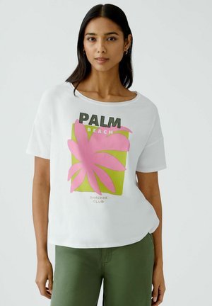 White short-sleeve T-shirt featuring a green square graphic with pink palm leaf and black text reading "PALM BEACH" and "SUNSHINE CLUB."
