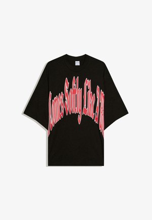 Fekete, túlméretezett póló nagy, ívelt piros és fehér felirattal elöl: "Comes Softly Like a Tap".