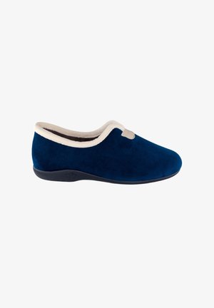 Zapatilla de ante azul marino con forro de felpa beige y bordes redondeados suaves. Presenta una suela negra flexible para mayor comodidad y soporte.