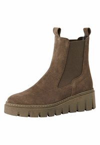 Bottine en daim marron avec des panneaux latéraux élastiques, bout rond et une semelle épaisse et robustes présentant un motif en zigzag distinct.