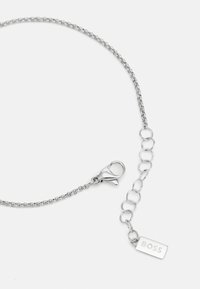Colier din argint cu un închizător tip homar, linkuri ajustabile și o etichetă rectangulară cu inscripția "BOSS". Design simplu și elegan.