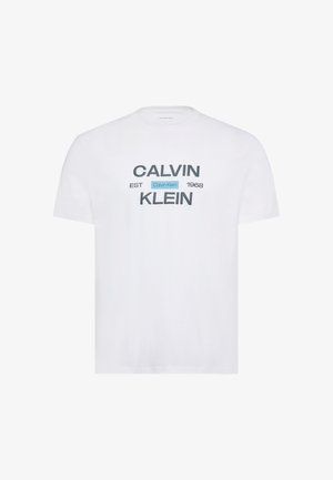 Bílé tričko s krátkým rukávem s nápisem „Calvin Klein EST 1968“ ve velkém šedém a černém textu na přední straně.
