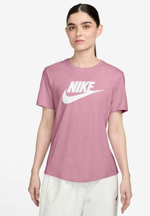 T-shirt in cotone rosa con maniche corte, caratterizzato da un prominente logo Nike bianco sul petto. Texture liscia e vestibilità ampia.