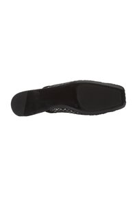 Zapato plano de malla negra con una suela suave y texturizada. Presenta una puntera afilada y un suave logotipo en la plantilla.