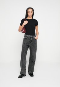 Melna T-krekls, brīva stila pelēkas džinsa bikses ar nodiluma detaļām, melni apavi un neliela bordo krāsas rokassoma. Vienkāršs, ikdienišķs tērps.