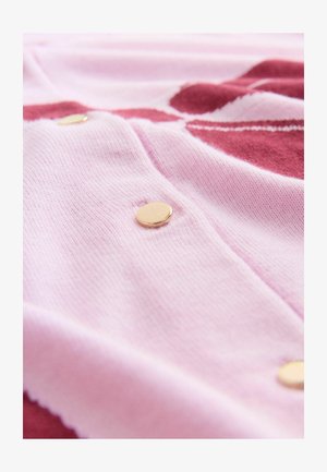 Light pink knit fabric with a textured pattern, featuring gold circular buttons and a smooth finish, with burgundy accents in the background.