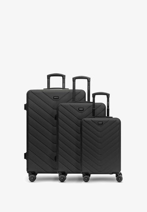 Trois valises noires de tailles graduées avec un motif en chevrons sur la surface, des poignées extensibles et des roues lisses et pivotantes.