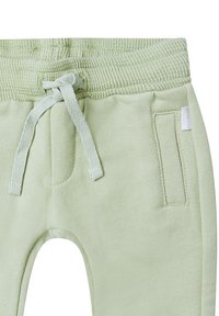 Lichtgroene katoenen sweatpants met een geribbelde tailleband, trekkoord en zijzakken; zachte textuur en casual ontwerp.