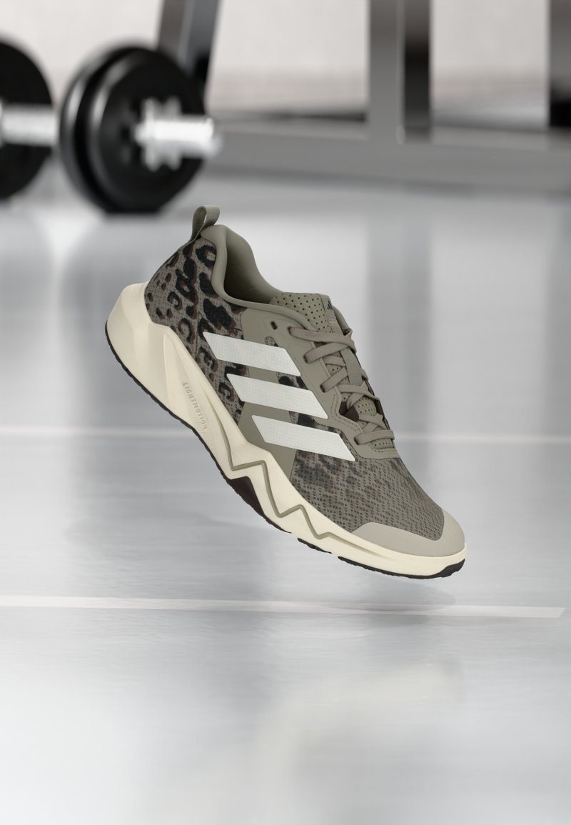 Chaussure de sport légère beige avec des accents à imprimé léopard, comportant trois bandes blanches, une tige texturée et un design de semelle en zigzag.