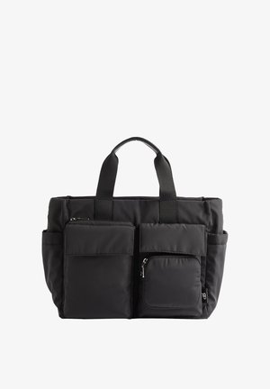 Mustat kangaskassit, joissa on kaksi etutaskua, joista toinen vetoketjullinen, kestävät hihnat ja pehmustettu muotoilu. Sileä pinta ja yksinkertainen muoto.