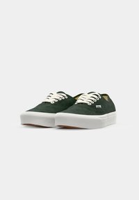 Grüne Wildledersneaker mit weißen Schnürsenkeln und Gummisohlen. Verfügt über ein flaches Design und ein kleines Markenlabel an der Seite.