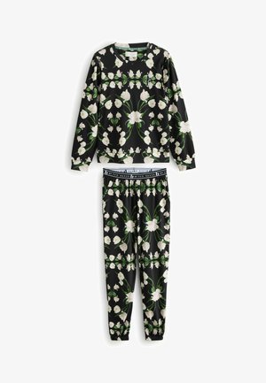 Ensemble de vêtements d lounging à motif floral comprenant un haut noir à manches longues orné de fleurs blanches et un pantalon de jogging assorti avec taille élastique et poignets.