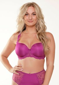 Magenta beha met zachte, gepadde cups, kantafwerking en een decoratieve strik in het midden. Gecombineerd met bijpassende high-waist onderbroek met kantaccenten.